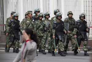 In this May 23, 2014 file photo, paramilitary policemen with shields and batons patrol near the People's Square in Urumqi in China's northwestern region of Xinjiang.